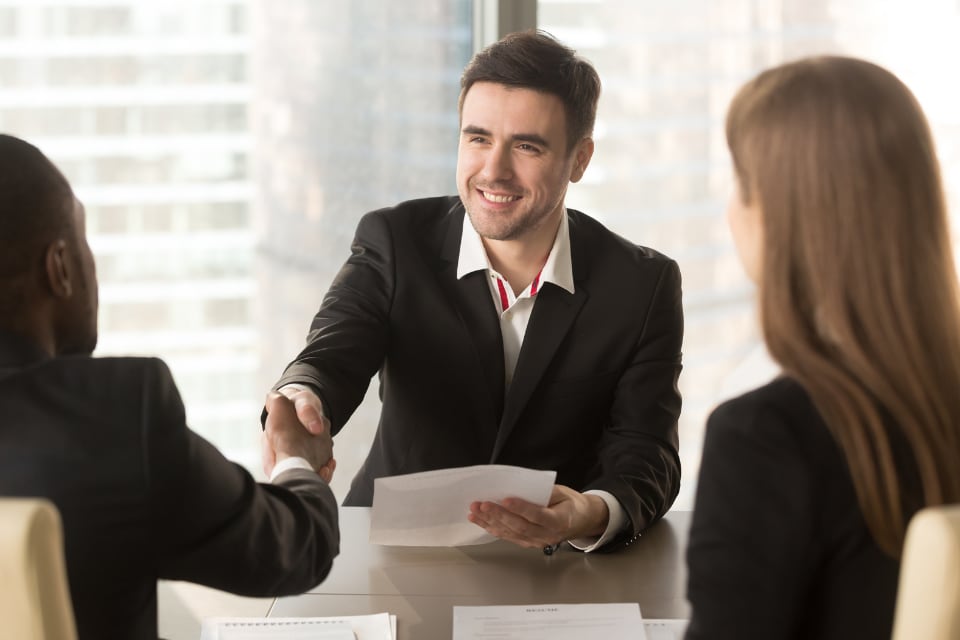man shaking hands with team